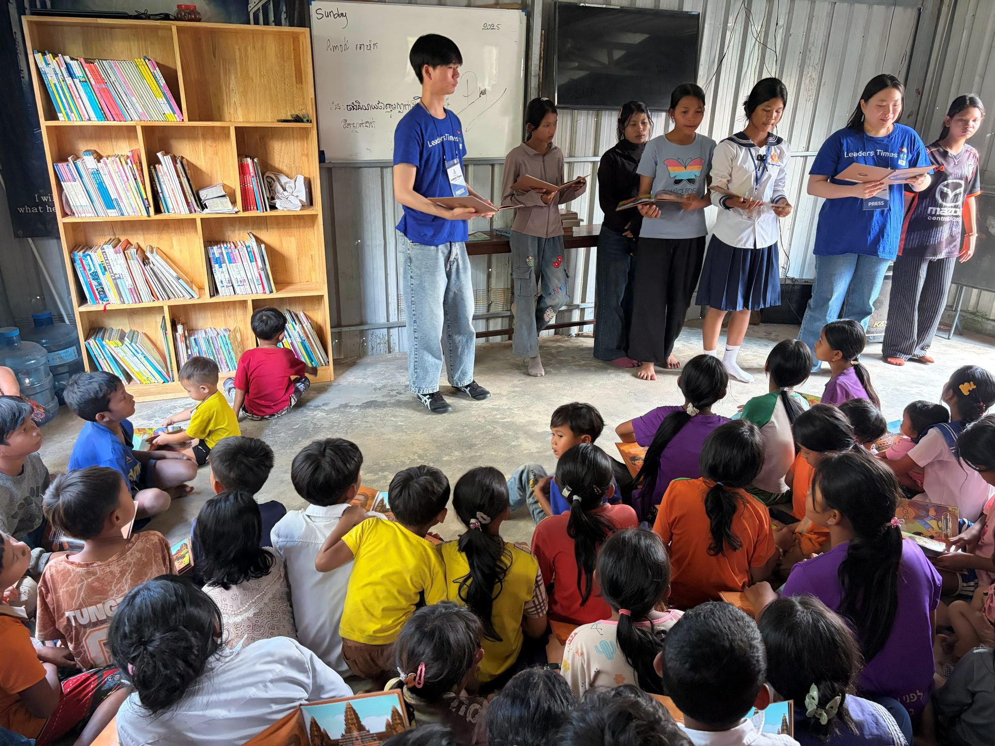 Speaking to children and families at a library opening, introducing books written in the languages they actually read.